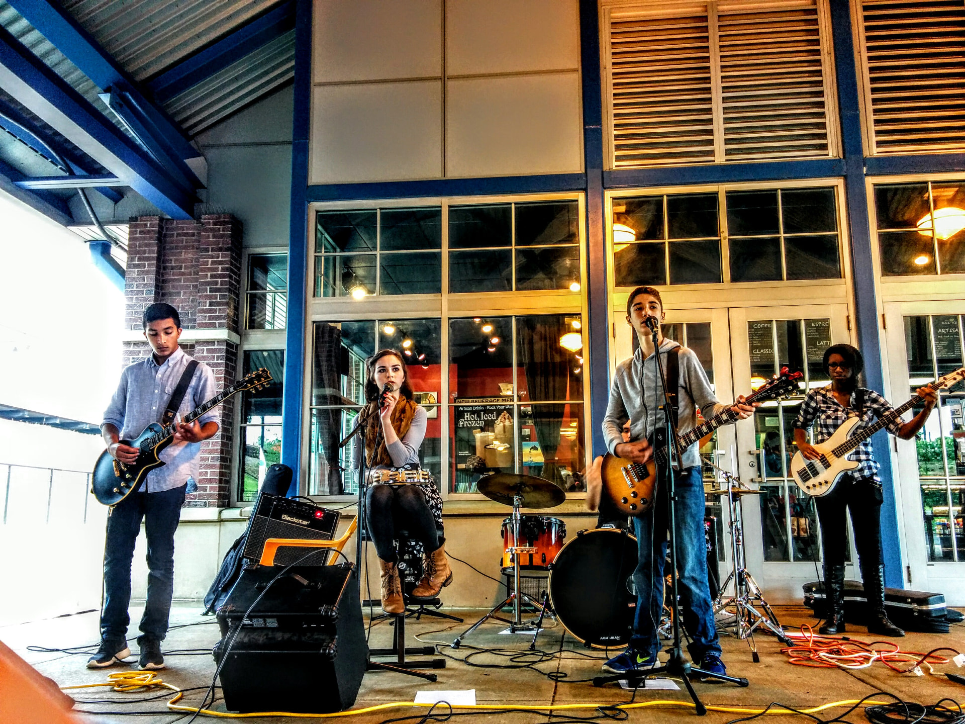 An NJWA teen band performing with guitars, bass, drums and a vocalist at a coffeehouse