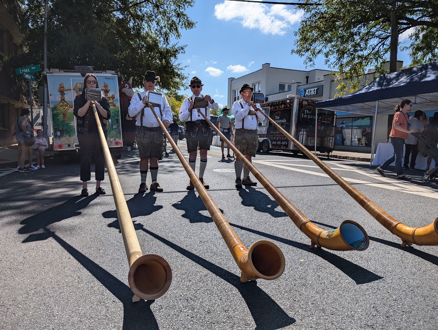 Alphorn bells and players in traditional dress at a festival performance