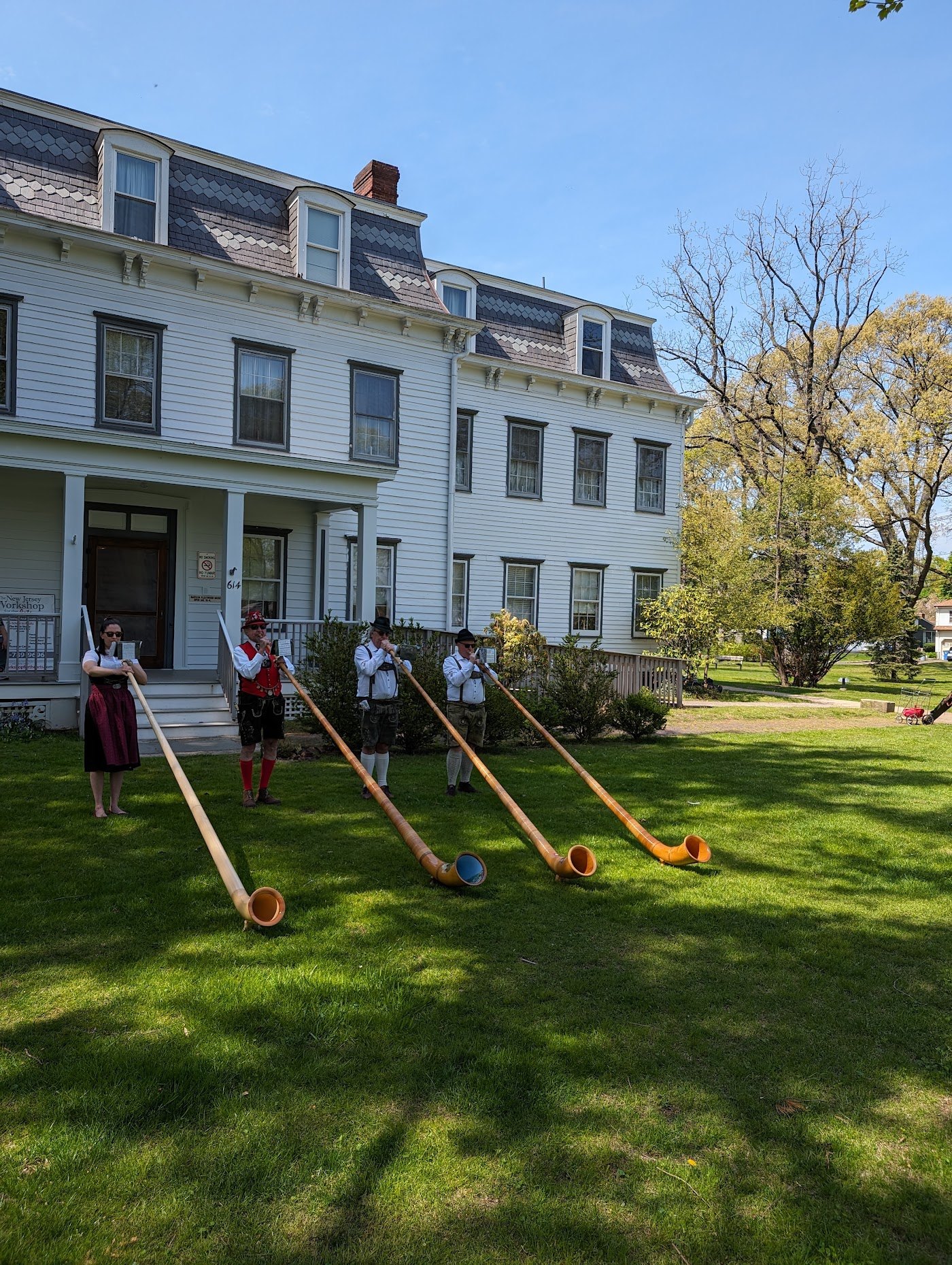 The NJWA Alphorn Ensemble performing on the lawn in front of a historic mansion