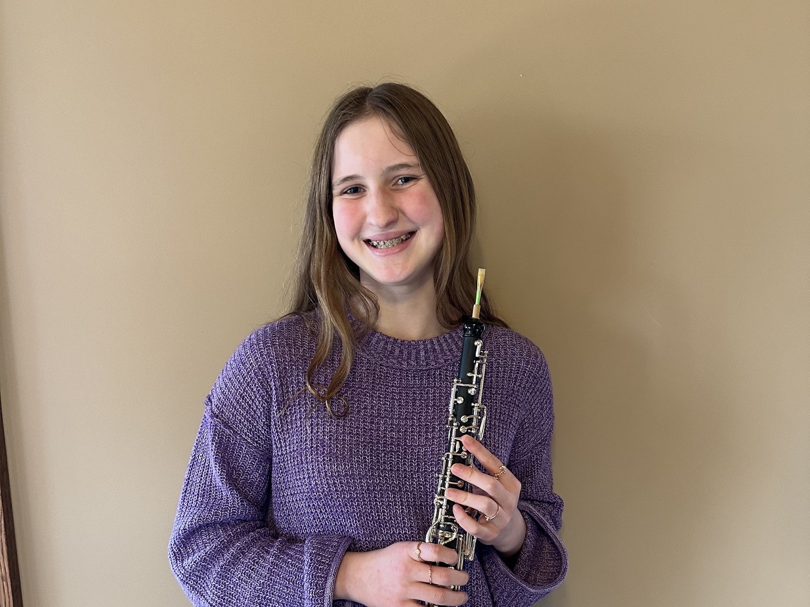 An NJWA student smiling and holding her oboe