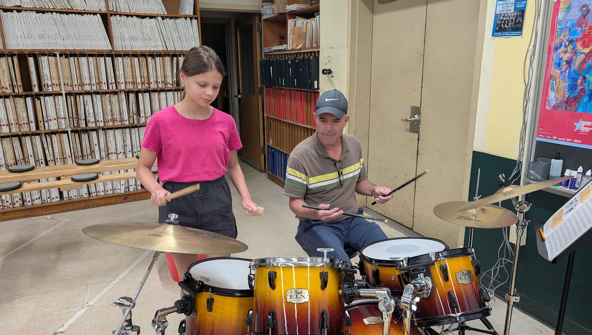 A student at the drum kit with her NJWA percussion teacher